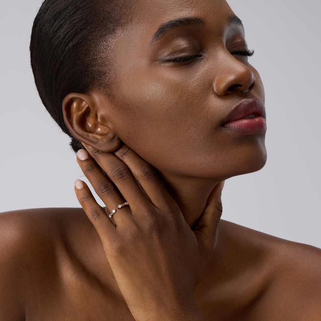 Woman touching neck wearing Club Lux Stackable Open Band Ring, rhodium plated 925 silver, simulated diamonds.