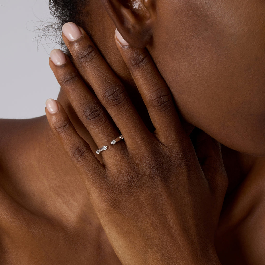 Close-up of hand wearing Club Lux Stackable Open Band Ring, rhodium plated 925 silver, simulated diamonds.
