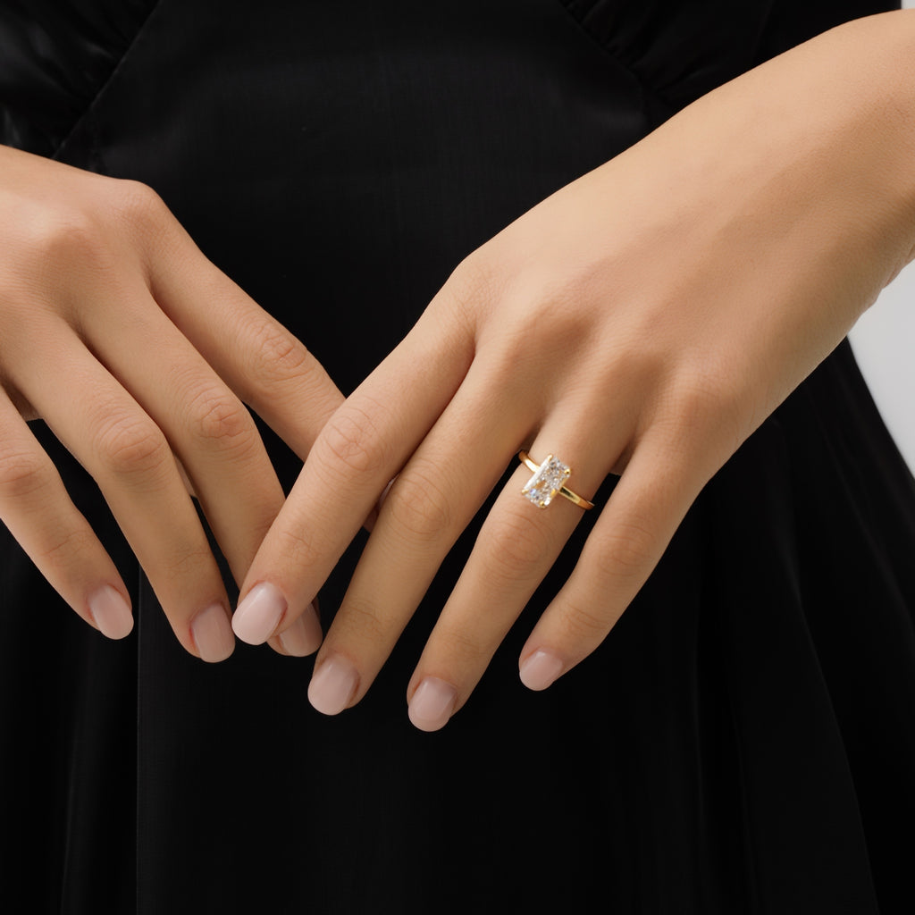 Close-up of a hand wearing a gold ring with a diamond on a black background
