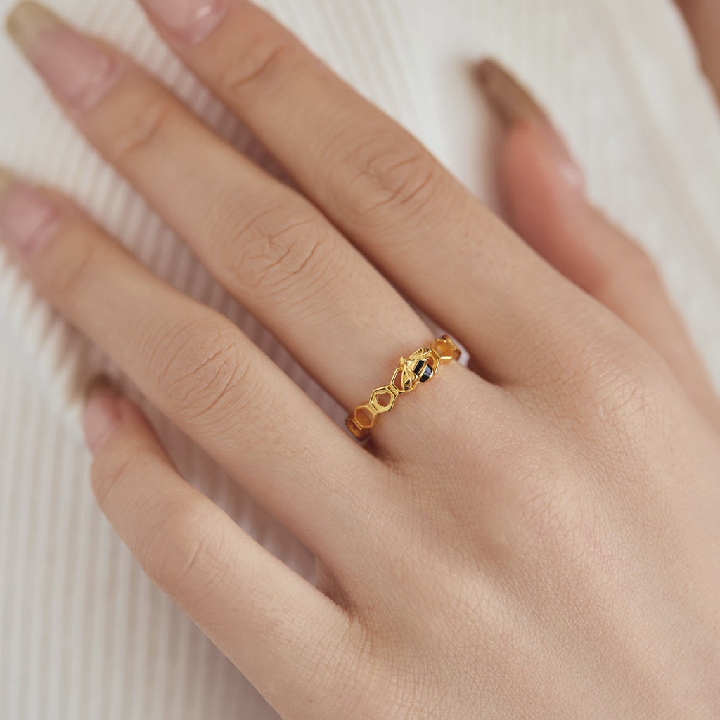 This playful ring celebrates nature's art! A gleaming golden honeybee perches in a hollow honeycomb. A bee symbol can represent boundless love and support. A sweet surprise for your honey or a treat for you!