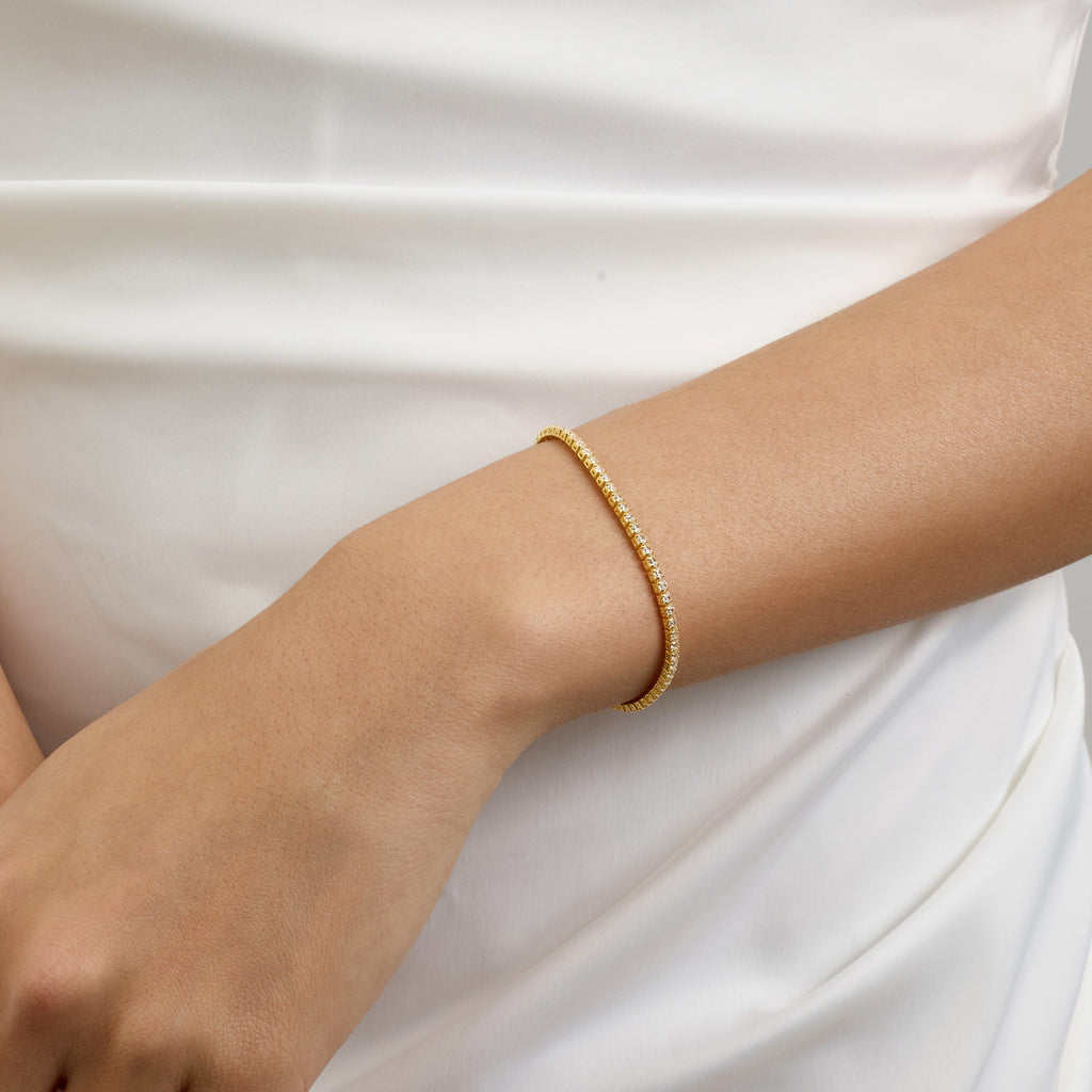 Top View of Woman Wearing 2mm Round Tennis Bracelet with White Silk Dress – Delicate and Sophisticated