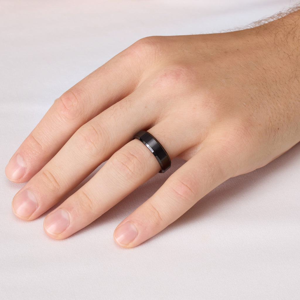 Black titanium wedding band on hand – detailed view of beveled ring edge