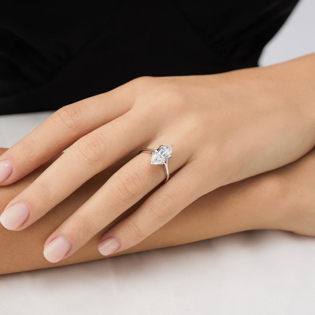 Close-up of marquise cut solitaire ring on finger – detailed view of elongated stone and pointed tips for maximum brilliance.