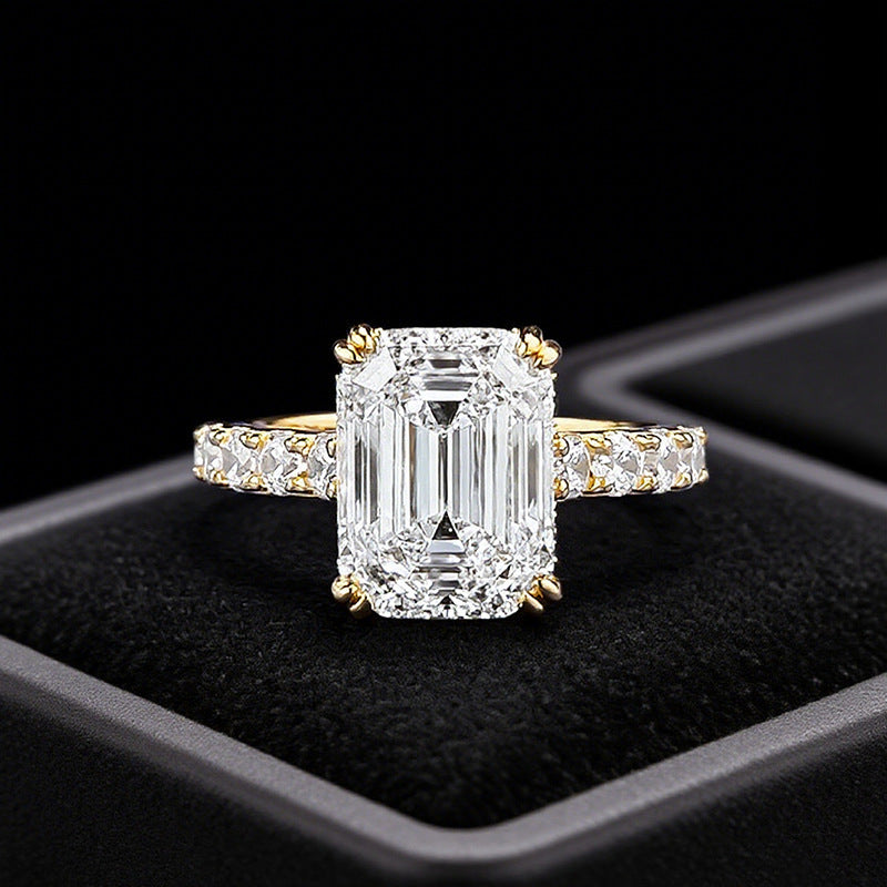Club Lux 5ct emerald cut engagement ring front view on ring box, hidden halo, cathedral setting, full eternity band