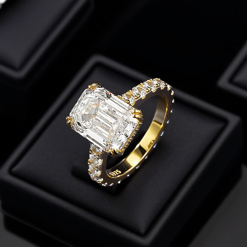 Club Lux 5ct emerald cut engagement ring top view on ring box, hidden halo, cathedral, full eternity band