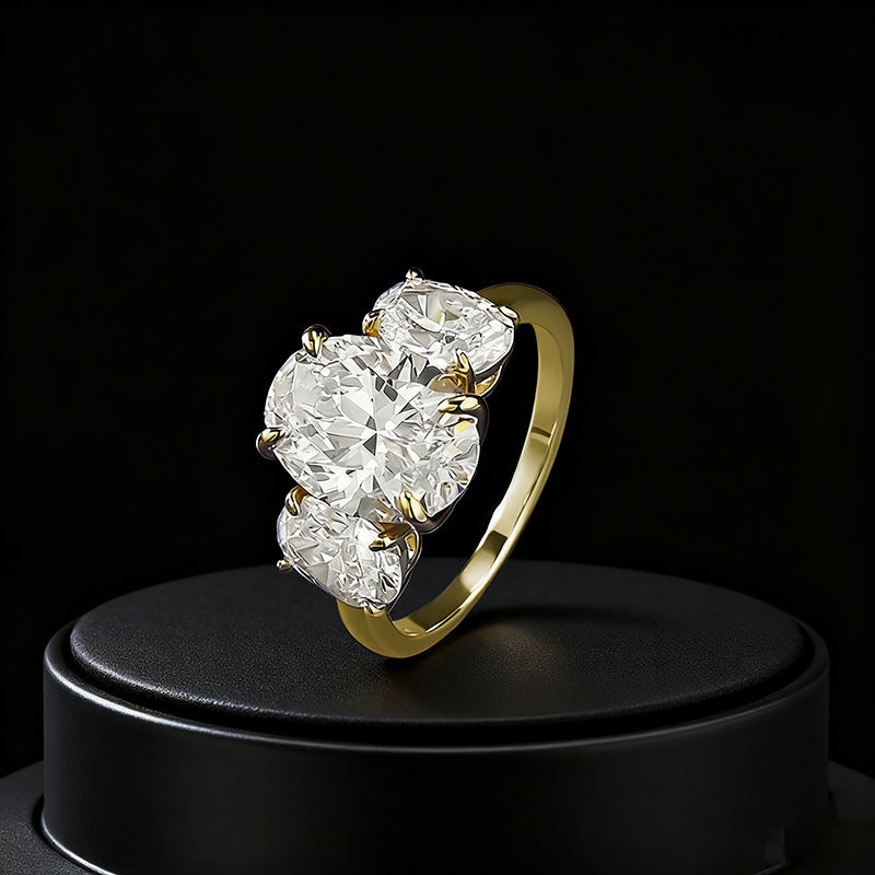 Three-quarter angle view of gold oval trilogy engagement ring.
