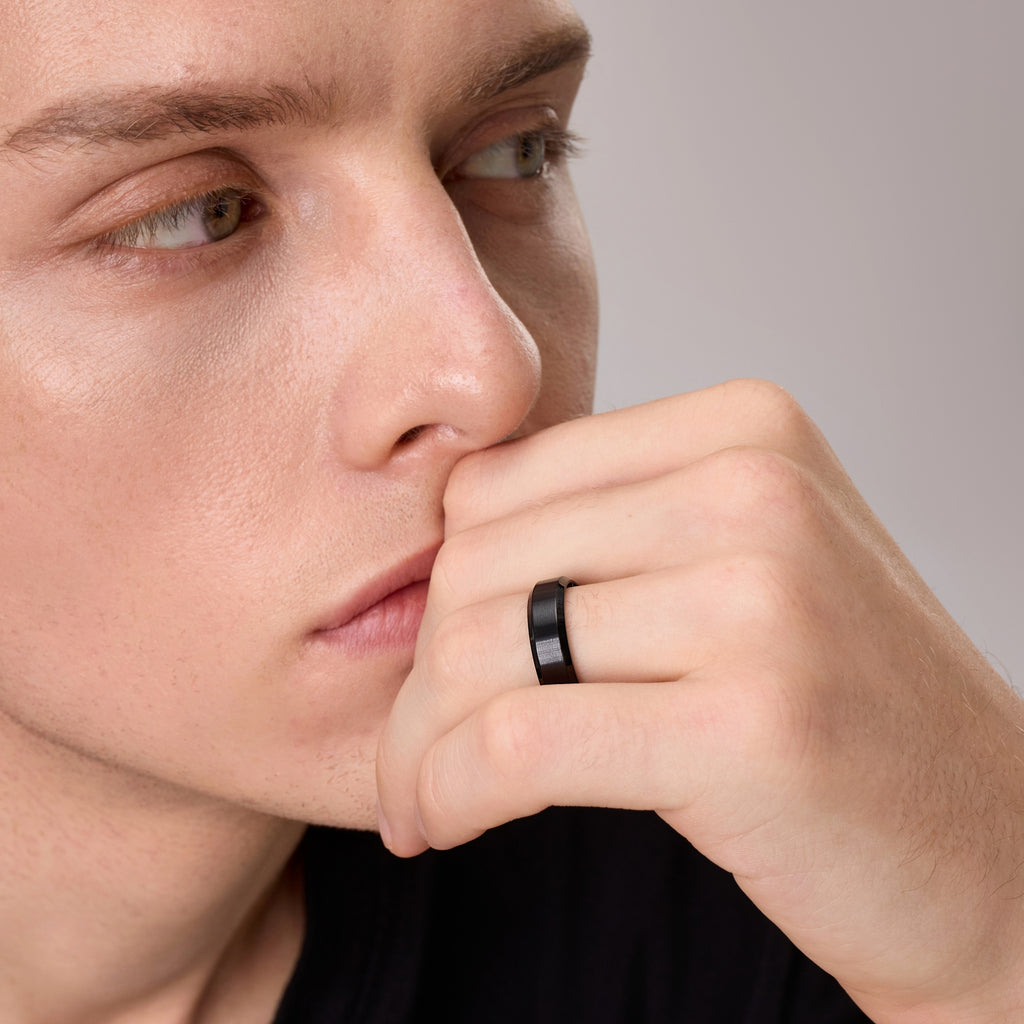 Man wearing black titanium ring near his face – close front view