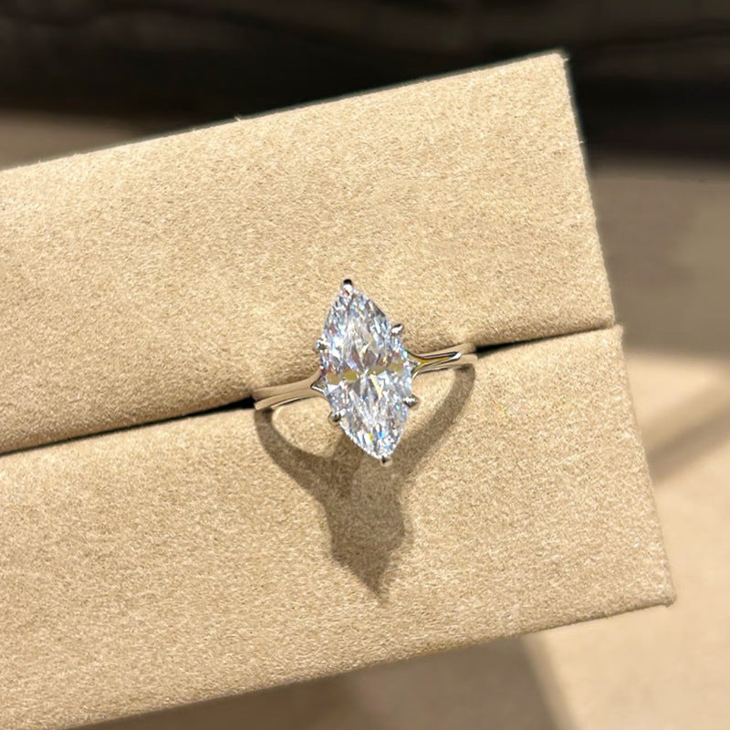 Marquise Cut Solitaire Engagement Ring sparkling under sunlight – brilliant simulated diamond on rhodium-plated silver band.