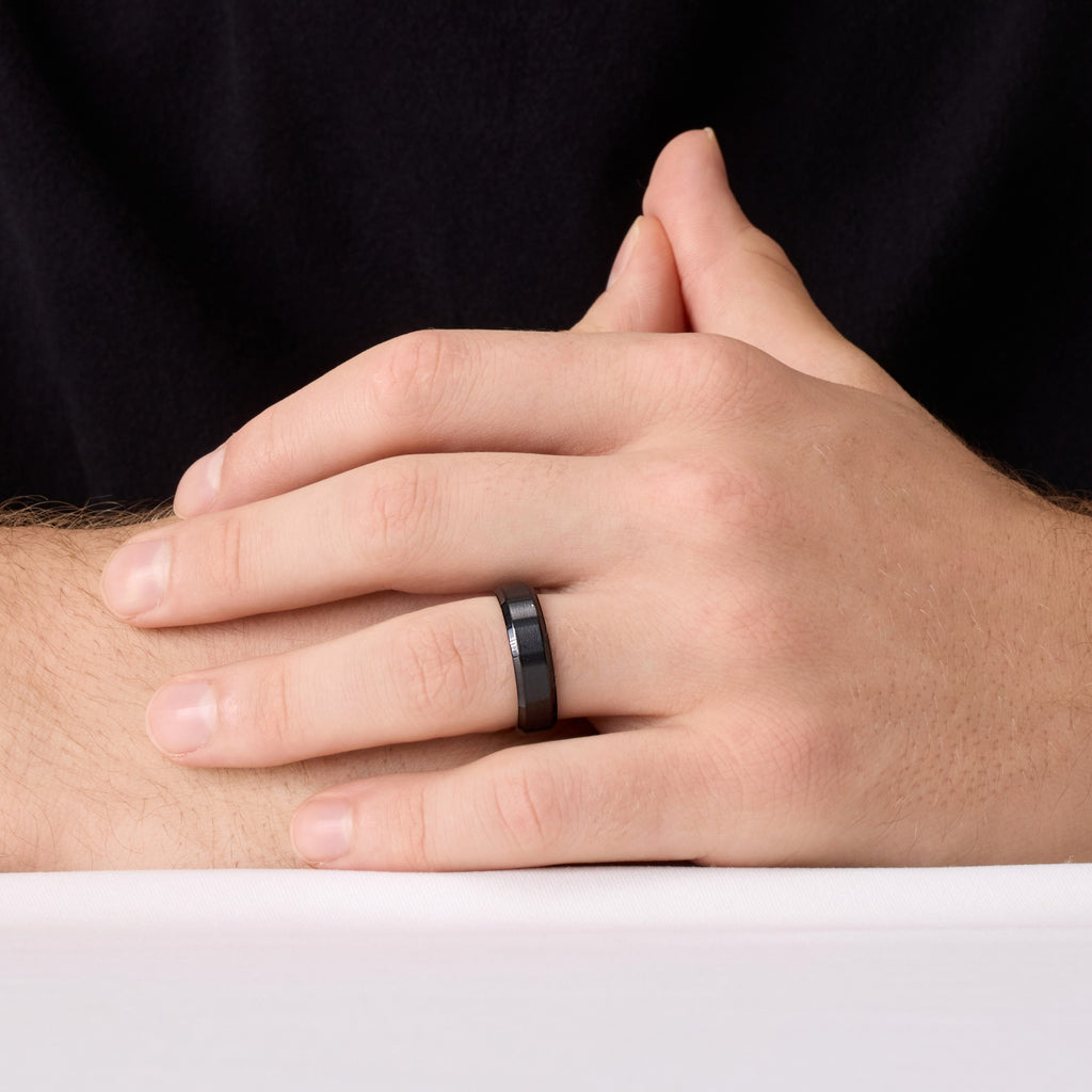 Men’s black titanium ring on hand – close front view