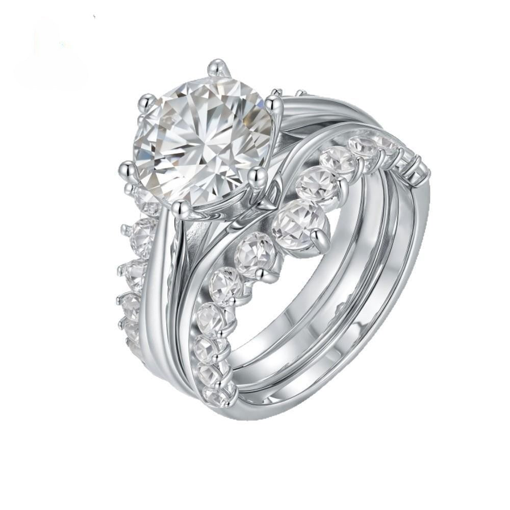 Top side view of 3 carat round moissanite cathedral engagement ring with enhancer wedding bands.