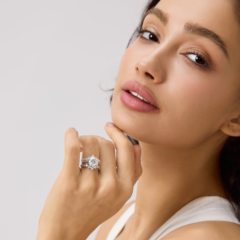 Close front view of woman wearing 3 carat round moissanite engagement ring bridal set.