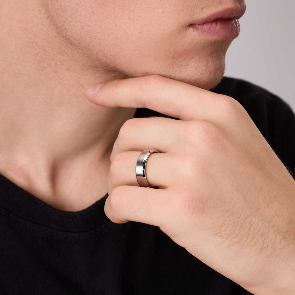 Close-up of men’s silver titanium wedding band on hand showing beveled edge